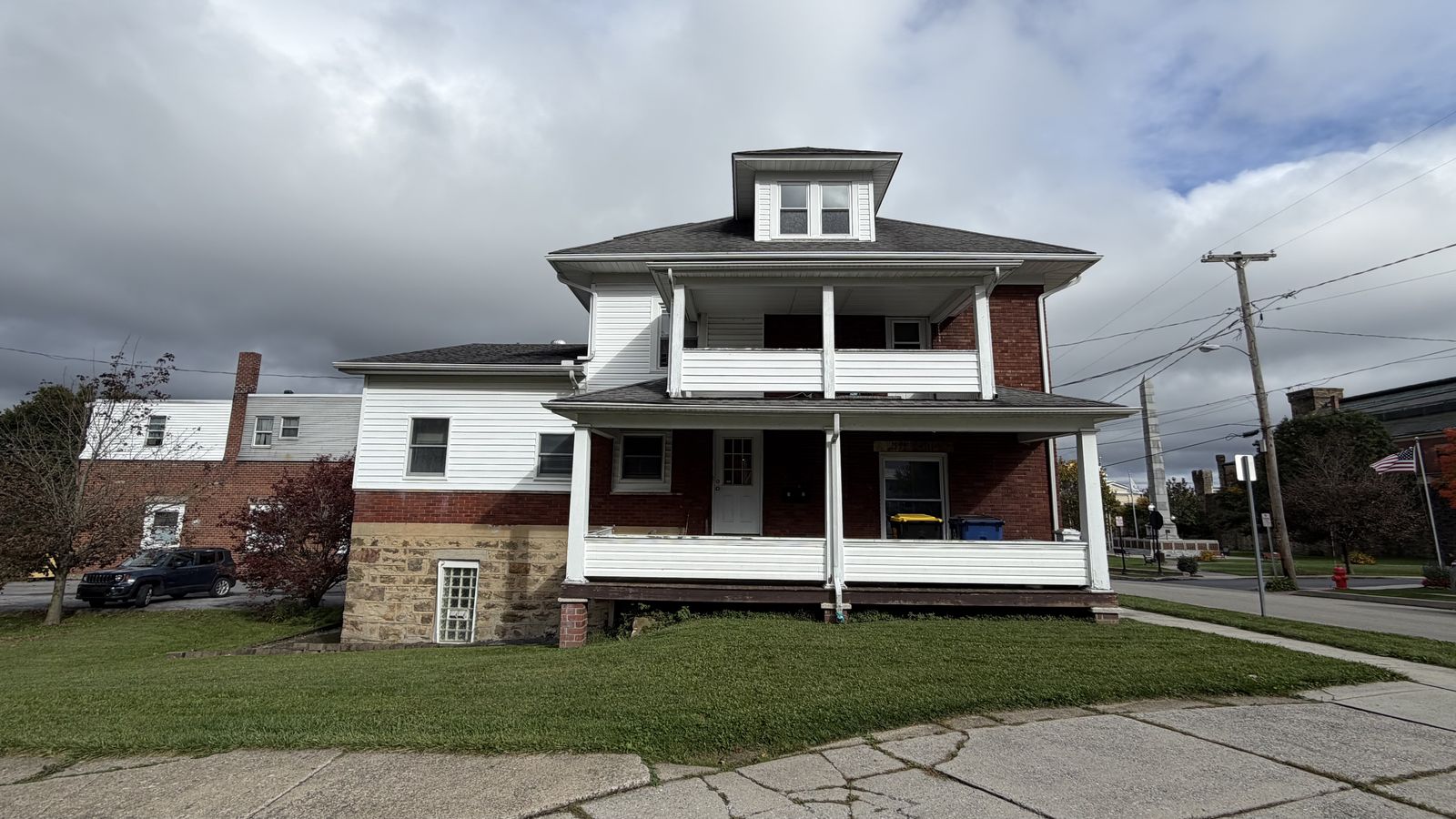 Front of 207 W Crawford Street in Ebensburg, a white and brick building with a two-story front porch.