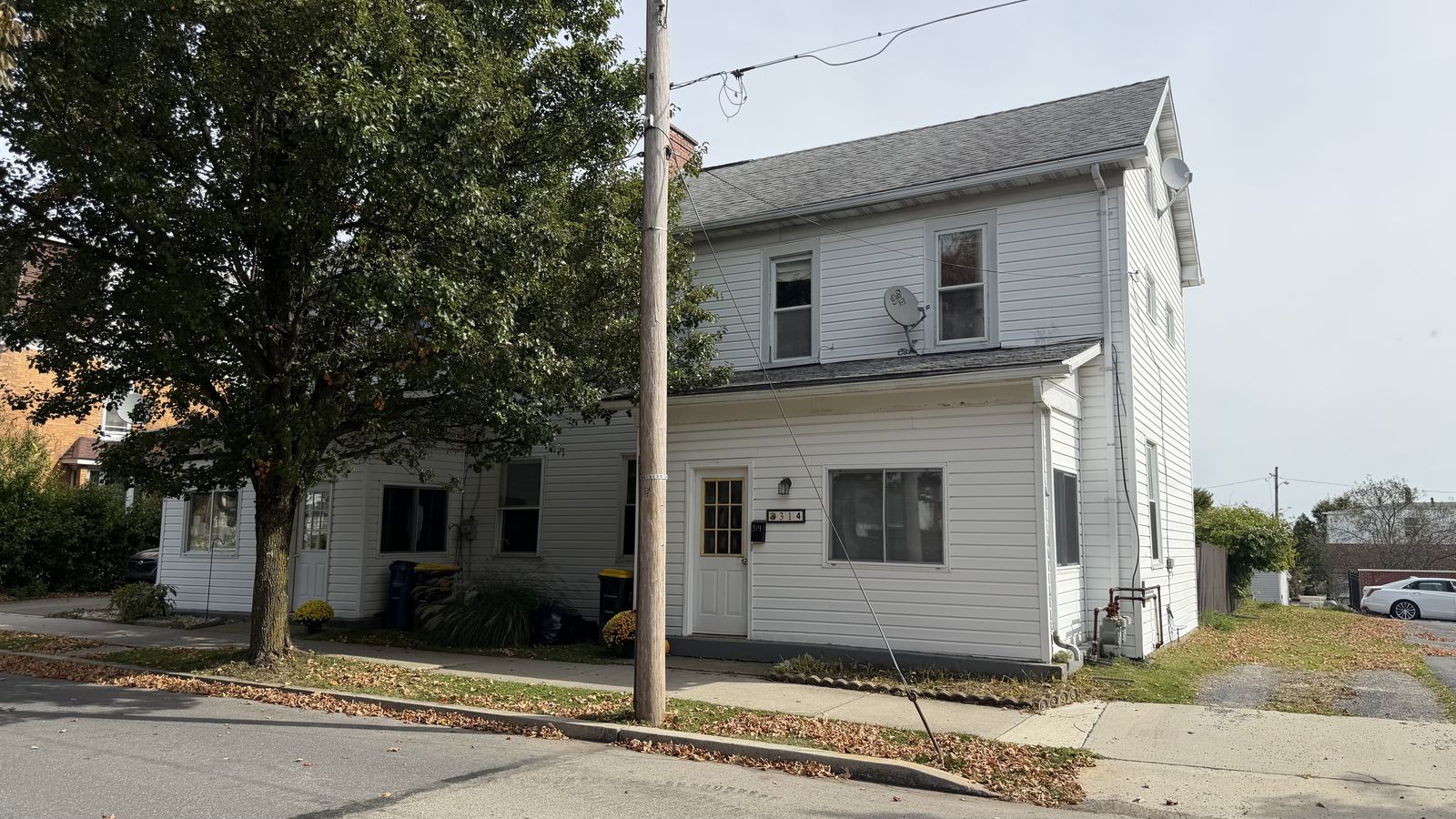 Front of 314-316 N Julian Street in Ebensburg, a white two-story duplex with the 314 entrance and a shade tree out front.